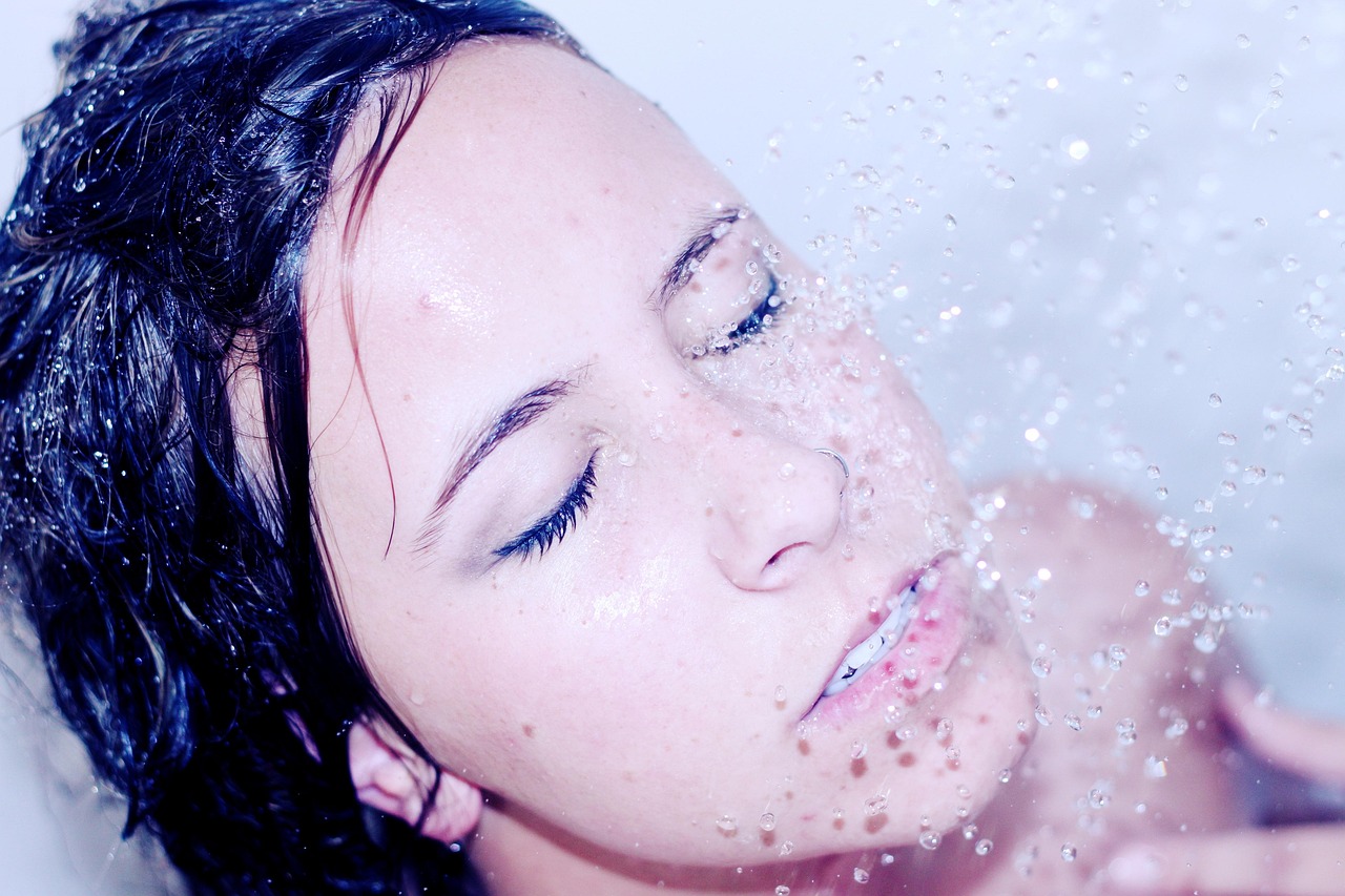 Woman with glowing clear skin washing her face
